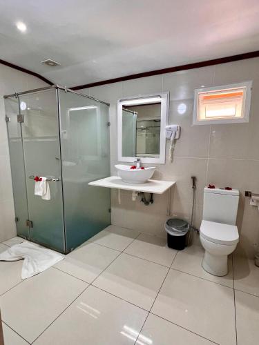 a bathroom with a toilet and a sink and a shower at Villa Chez Batista in Takamaka