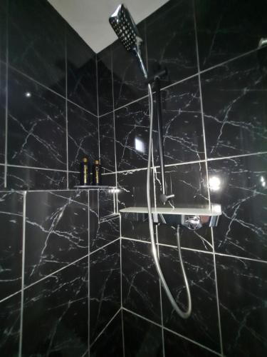 a bathroom with a shower with a black marble wall at Apartman Ogulin "Klek Escape" in Sveti Petar