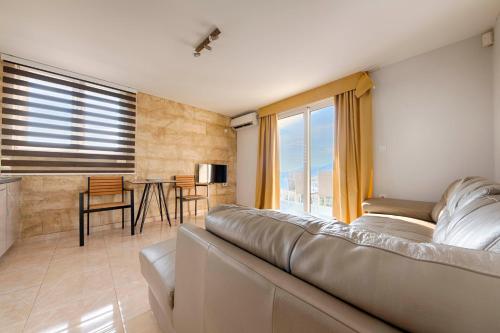 a living room with a couch and a table at ZIS LUX Apartments Pool in Utjeha