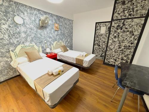 a room with two beds and a chair in it at Evans Realty - Hostal in Fuengirola
