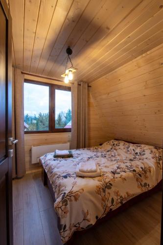 a bedroom with a bed in a wooden cabin at DB Forest Resort in Bucsin