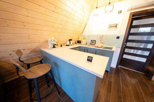 a kitchen with a counter and stools in a cabin at DB Forest Resort in Bucsin