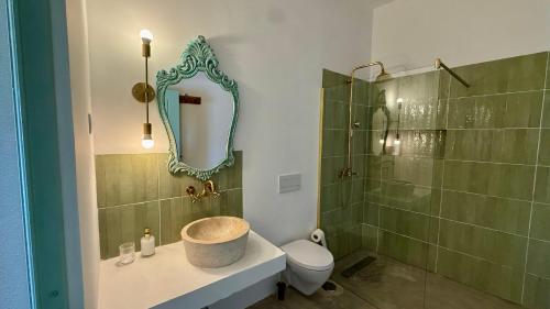 a bathroom with a sink and a toilet and a mirror at Casa D'avó Souzinha in Ermidas