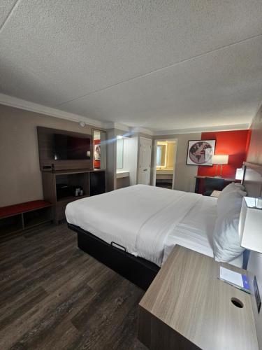 a hotel room with a large bed and a table at Ramada by Wyndham Westminster Denver in Westminster