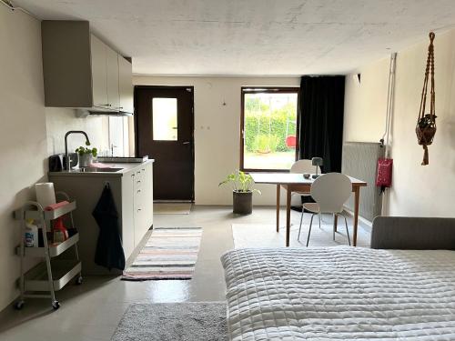 a bedroom with a bed and a kitchen with a table at Sommarboende i centrala Varberg in Varberg