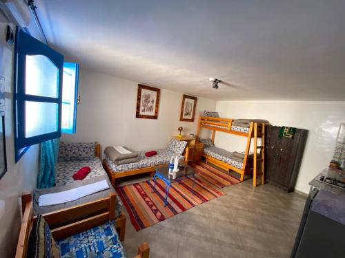 a room with two bunk beds and a table at Villa Azzurra in Imsouane