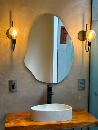 a bathroom with a round sink and a mirror at Casa Super Paradise in Rio Tinto