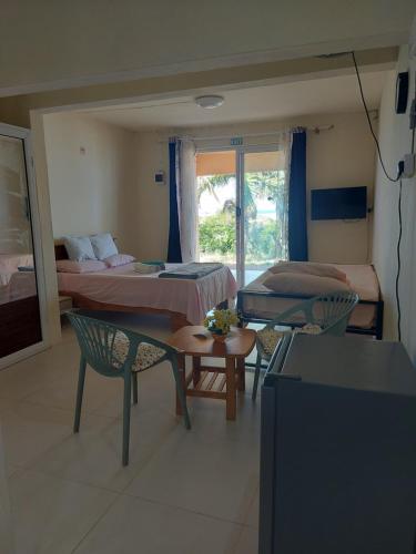 a room with two beds and a table and chairs at Le Toit Enchanté in Port Mathurin