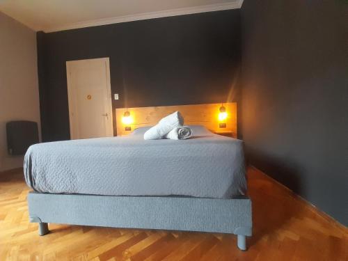 a bedroom with a large white bed with two pillows at Mora Hostel in Mendoza