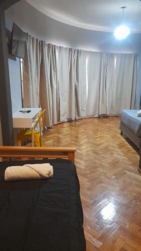 a living room with a bed and a table and a tableablish at Mora Hostel in Mendoza