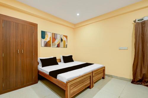 a bedroom with a bed and a wooden cabinet at Spot ON Hotel Gyanvi Palace in Bhopal