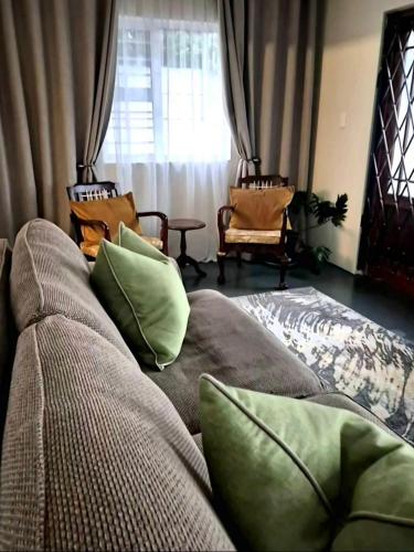 a couch with pillows on it in a living room at Fortune Cottage in Cape Town