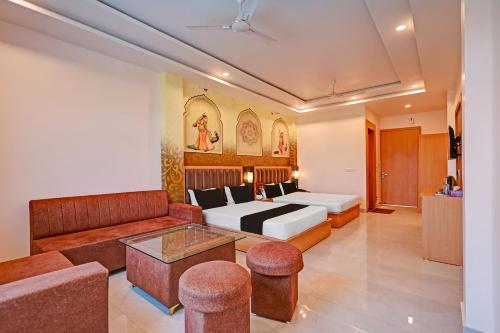a hotel room with a bed and a couch at Hotel O Gomti Garden And Resort in Jhānsi
