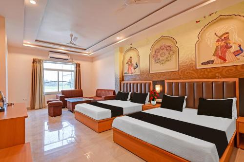 a hotel room with two beds and a couch at Hotel O Gomti Garden And Resort in Jhānsi