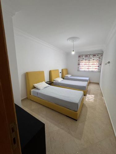 a room with three beds and a window at Saramica Apartamento in Riffiene