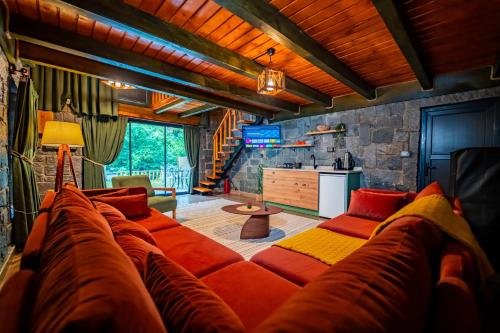 a living room with a large couch and a kitchen at Dolana Wadi Taş Evleri in Pirinçlik