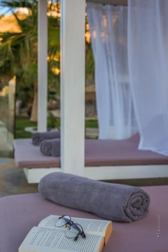 a book and glasses sitting on a table with a pillow at Blue Vedere in Agia Pelagia