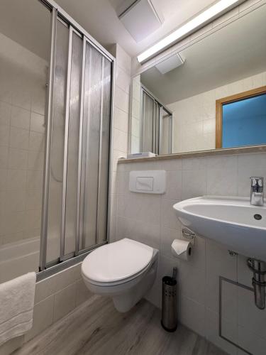 a white bathroom with a toilet and a sink at Hotel Hasen Kaufbeuren Allgäu in Kaufbeuren