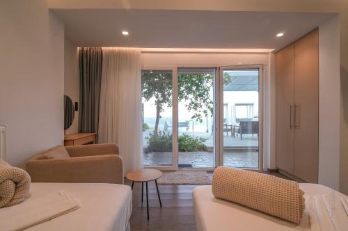 a living room with two beds and a sliding glass door at Blue Vedere in Agia Pelagia