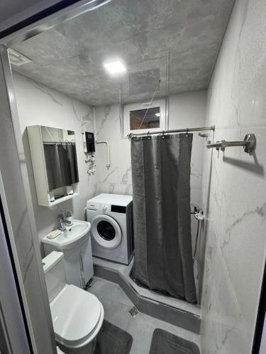 a small bathroom with a toilet and a washing machine at Avenue B&B in Vanadzor