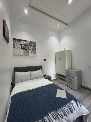 a bedroom with a bed and a cabinet in it at Tameeza stays in Sangotedo