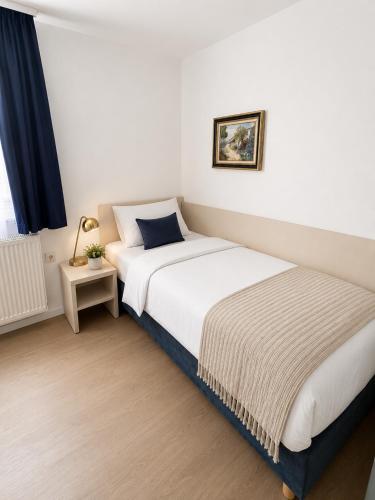 a hotel room with two beds and a lamp at Hotel Mainbrücke in Kitzingen