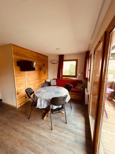 a room with a table and chairs and a couch at Le Chalet de Super D in Le Dévoluy