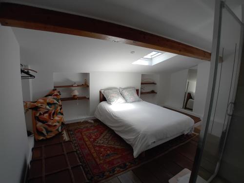 a small bedroom with a bed with white sheets and pillows at Casetta - Appartement dans maisonnette rustique in Cognocoli-Monticchi