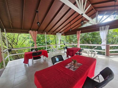 a living room with a red table and chairs at Royal Escape - 1 in Anse La Raye