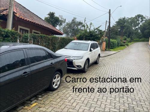 two cars parked in a driveway next to a house at Apartamento Duda 03 in Monte Verde