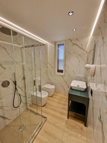 a bathroom with a shower and a sink and a toilet at Hotel La Giara in Cefalù