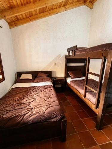 a bedroom with two bunk beds and a chair at Hotel Lancers in Paipa