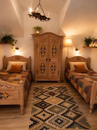 a bedroom with two beds and a large cabinet at Levendula udvarház in Sopron
