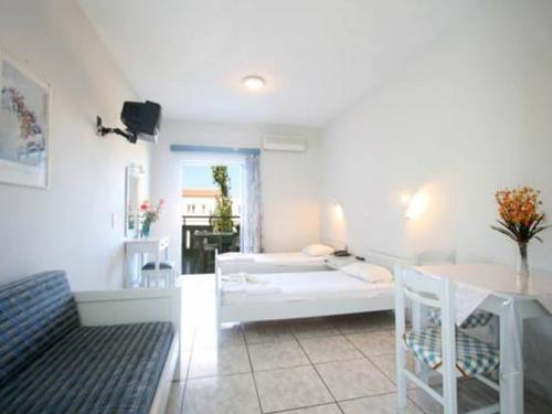 a living room with a white couch and a table at Hotel Kleopatra in Stalos