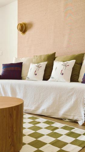 a couch with pillows on it in a living room at Cap Almyra, on Lavasina Beach, Erbalunga in Brando