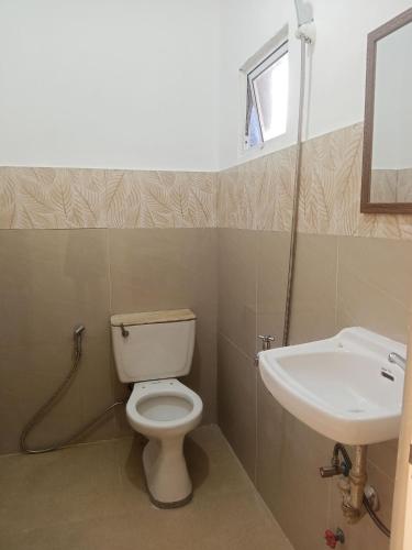 a bathroom with a toilet and a sink at V Hostel Galera in Puerto Galera