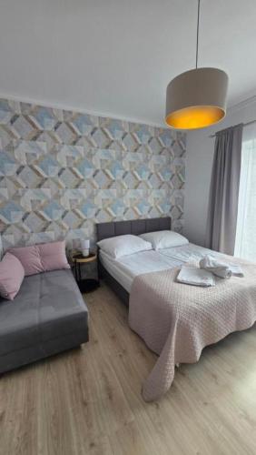 a bedroom with a bed and a couch and a table at Villa Dolce Vita in Łeba