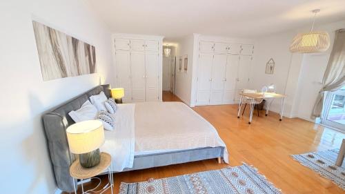 a bedroom with a large bed and a table at Oceanfront 2 bedrooms apartment with swimming pool & garage in Cascais