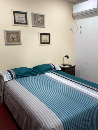 a bedroom with a bed with a blue and white blanket at Casa familiar in Corrientes