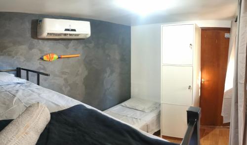 a small room with a bed and a air conditioner at Container Hospedaria Paraty in Paraty