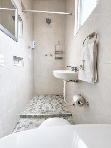 a white bathroom with a sink and a toilet at Hotel Museo Carnaval in Huejotzingo