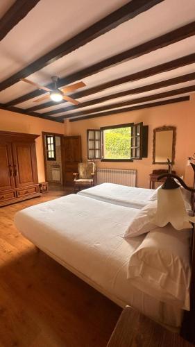 a large bedroom with a large white bed in a room at El Mirador de Deva in Deva