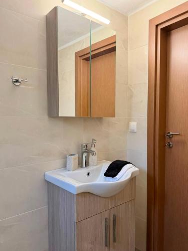 a bathroom with a sink and a mirror at STV Royal Apartments 3 in Areopoli