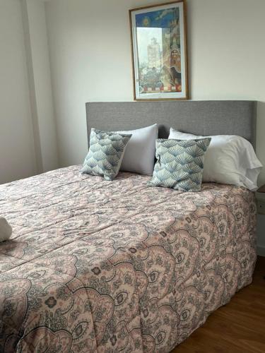 a bed with pillows and a blanket on it at Ventanas A LA CIUDAD in Mar del Plata