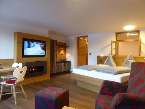 een hotelkamer met een bed en een televisie bij Dreimäderlhaus - Das vegetarische Boutique Hotel in Füssen