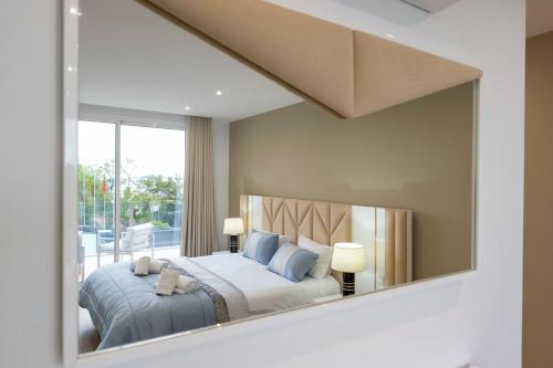a bedroom with a bed and a large mirror at Villa Machim - Heated Pool - View in Machico