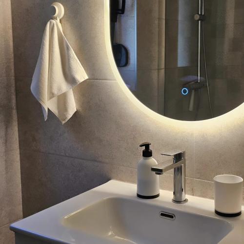 a bathroom sink with a mirror and a soap dispenser at FOREST apartments in Bijela