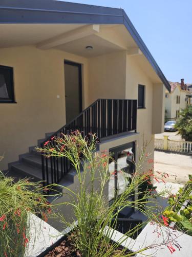 a house with a black staircase and some plants at FOREST apartments in Bijela