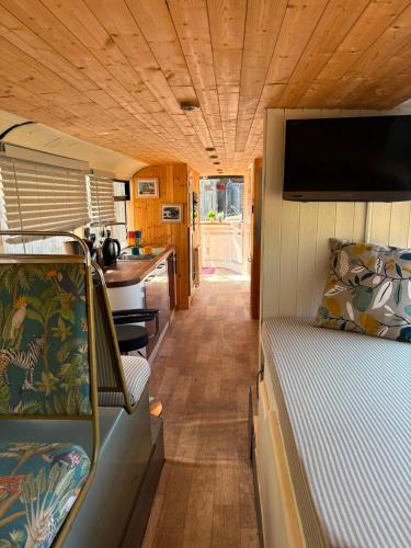 a room with a bed and a kitchen in a trailer at Debdale Bus Retreat in Little Dalby