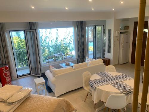 a living room with a couch and a table at Amfiteatriko Studio Sea View Oropos Attiki in Kalamos